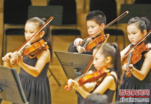 10月22日晚上,在渝中区重庆国泰艺术中心,小学生们在舞台上认真演奏。