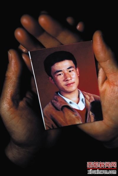 尚爱云捧着儿子的照片。 尚爱云捧着儿子的照片。